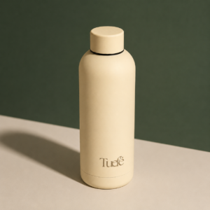 Botella de acero inoxidable Tuefe color beige arena de 500ml en superficie de madera